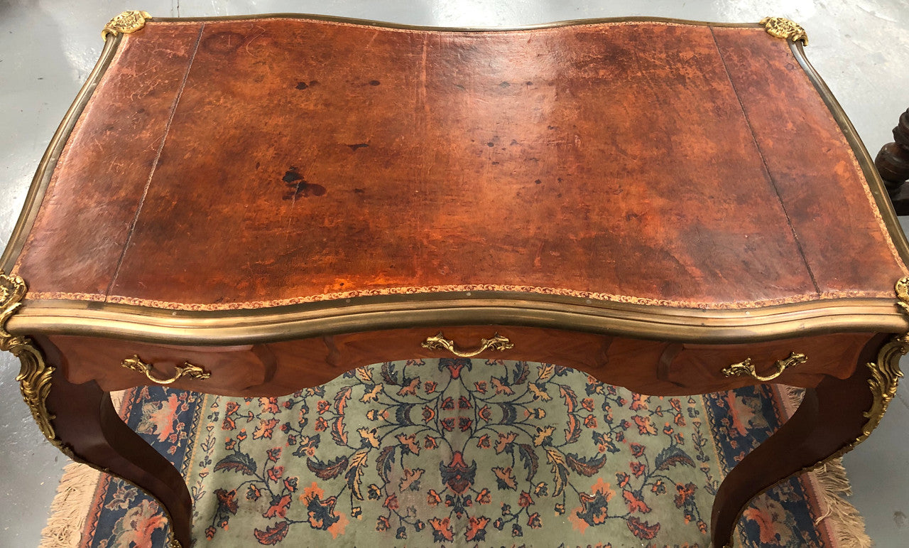 An impressive French Walnut petite Bureau Plat with superb ormolu mounts, original tooled leather top with loads of character and drawers for storage. It is in very good original detailed condition.