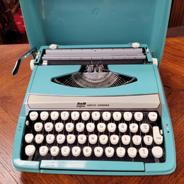 1960's Smith Corona Corsair deluxe portable typewriter. It is in working condition with a used ribbon, and comes with everything pictured. It has been sourced locally.