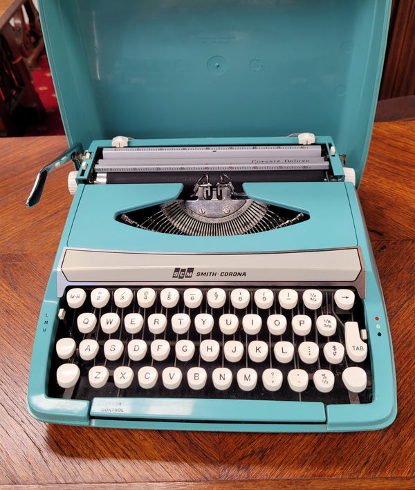 1960's Smith Corona Corsair deluxe portable typewriter. It is in working condition with a used ribbon, and comes with everything pictured. It has been sourced locally.