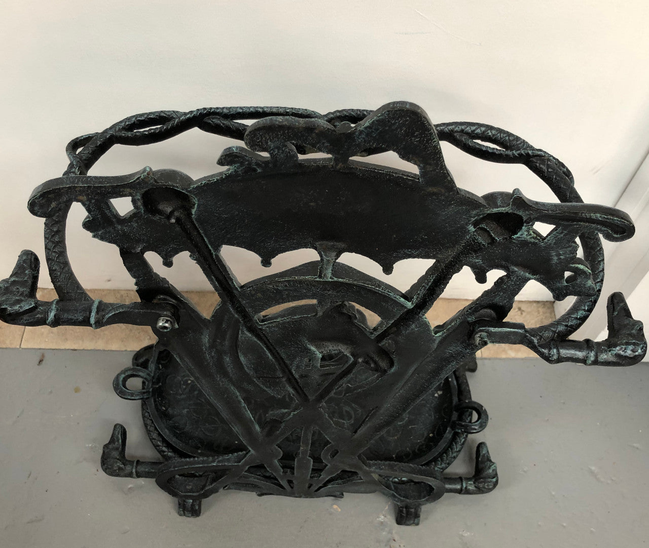 A black cast iron umbrella stand displaying a horse in the middle with four dogs on the side. In good original condition.