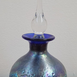 Stunning iridescent hand blown perfume bottle. Beautiful peacock blue, purple colours. Signed on base with clear glass stopper.