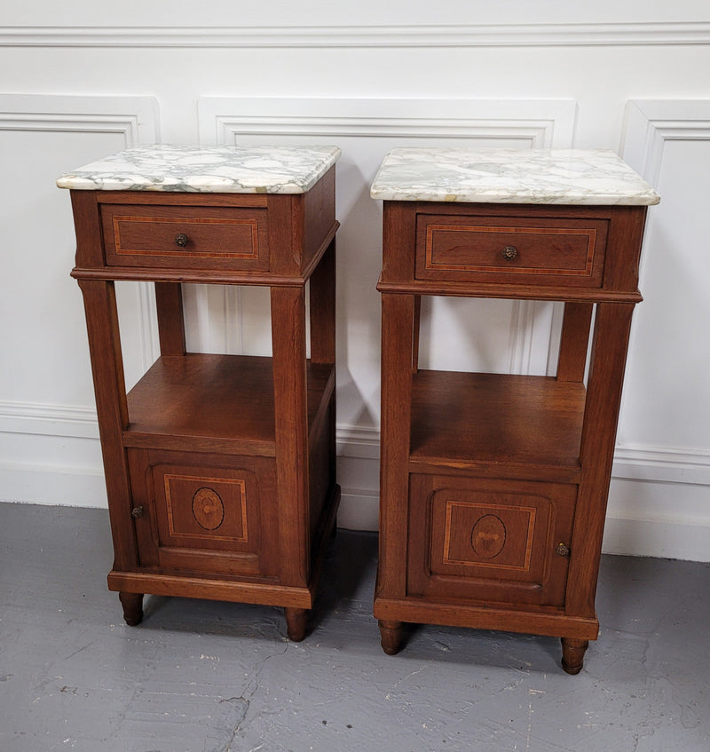 Pair of Antique French Oak Louis XVI style marble top bedside cabinets. They have decorative inlay and have been sourced from France. They are in good original detailed condition.