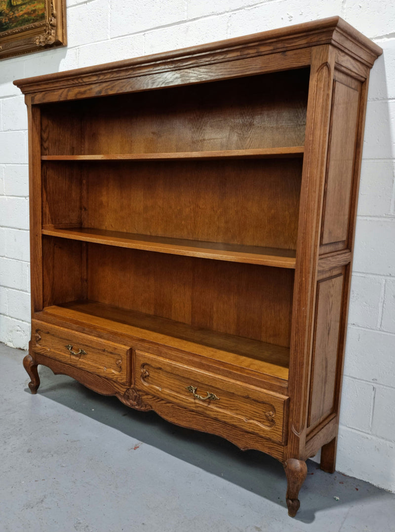 Lovely French Oak Louis XV style open shelf bookcase with two drawers for storage and three shelves in good original detailed condition.