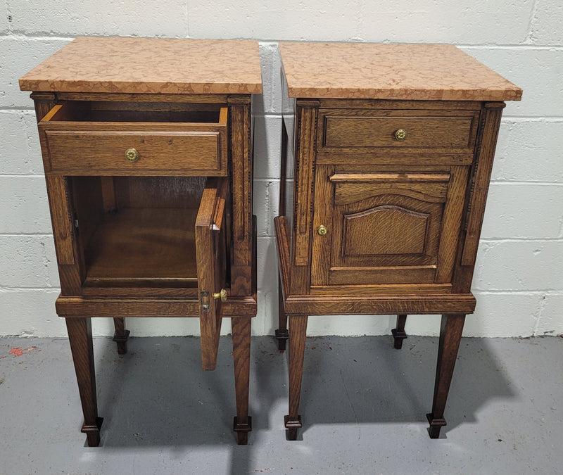 Beautiful pair of French oak bedside cabinets with marble tops. They have a drawer and cupboard for storage and are in good original detailed condition.