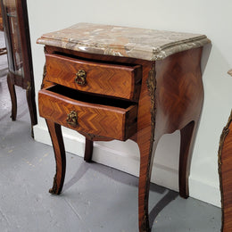 Pair of Louis XV commode style two drawer bedsides with beautiful marble tops and decorative mounts. They are a rare size and are in good, detailed condition.