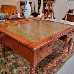 English Cedar full partners desk with attractive tooled leather top, four drawers either side and on caster wheels.  In good original detailed condition.