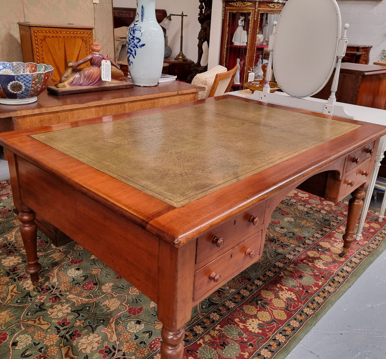 English Cedar full partners desk with attractive tooled leather top, four drawers either side and on caster wheels.  In good original detailed condition.