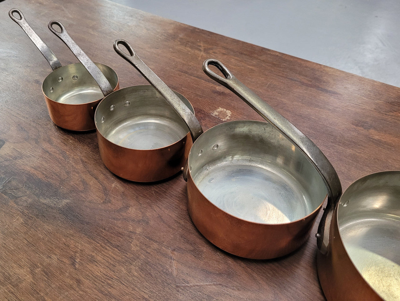 Set of five copper sauce pans with foundry stamp. They have been sourced from France and are in good original detailed condition.
