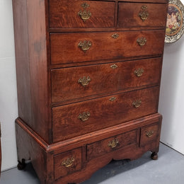 Early 19th Century English Oak chest on stand. It has been sourced in France and has plenty of storage space with eight drawers. In good original detailed condition.