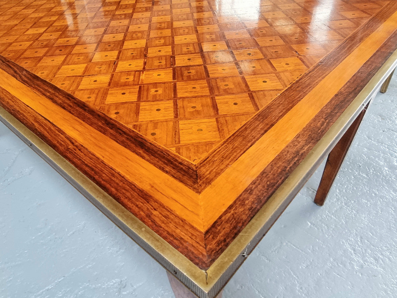 Beautiful French Louis XVI style inlaid coffee table with a brass band and glass top. In good original detailed condition.