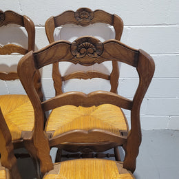 A set of 6 French Louis XV style oak dining chairs with rush seats in good original condition. All chairs have been detailed and re-glued where needed.