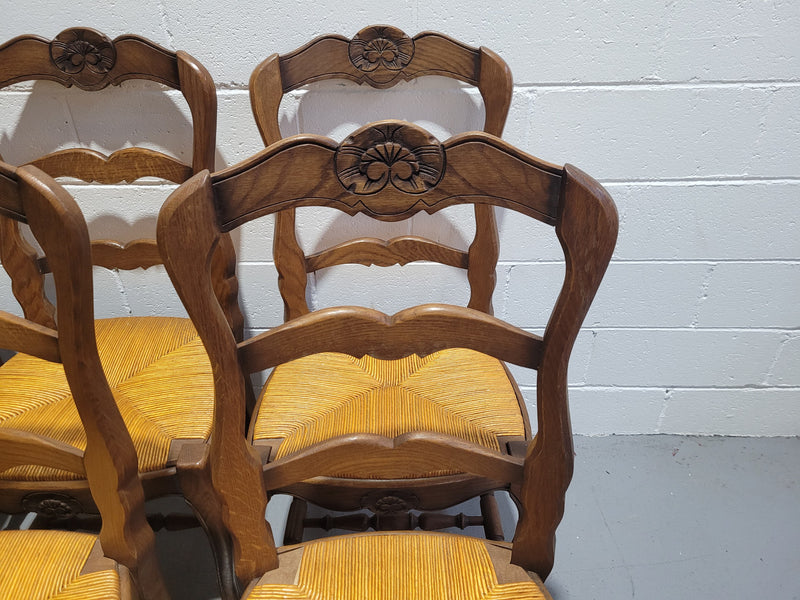 A set of 6 French Louis XV style oak dining chairs with rush seats in good original condition. All chairs have been detailed and re-glued where needed.