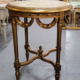 French Louis XVI style round marble topped gilded lamp/side table featuring lovely carved swags and undercarriage. It has been sourced from France and is in good original detailed condition.