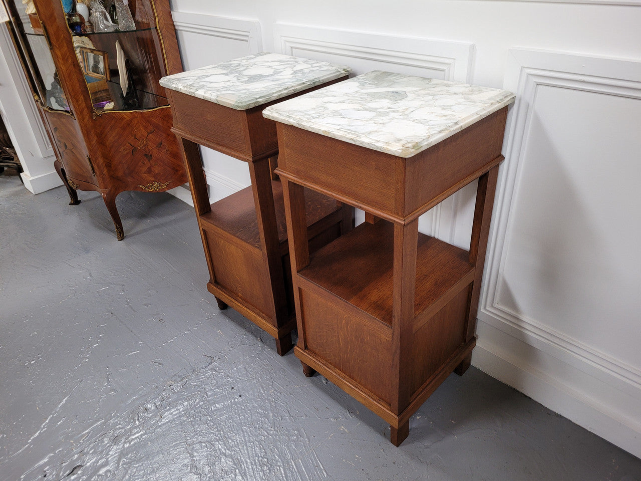 Pair of Antique French Oak Louis XVI style marble top bedside cabinets. They have decorative inlay and have been sourced from France. They are in good original detailed condition.