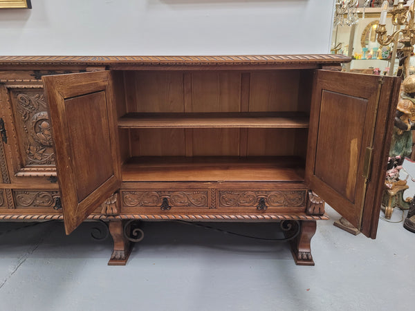 Large French Oak Renaissance style four door sideboard/buffet. Great decorative item with amazing carvings and stunning iron work on base. It is in good original detailed condition. Can pull apart completely making it easier to move.