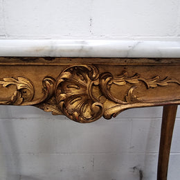 French Louis XV style carved center table with a stunning marble top and original gilt. In good original detailed condition.