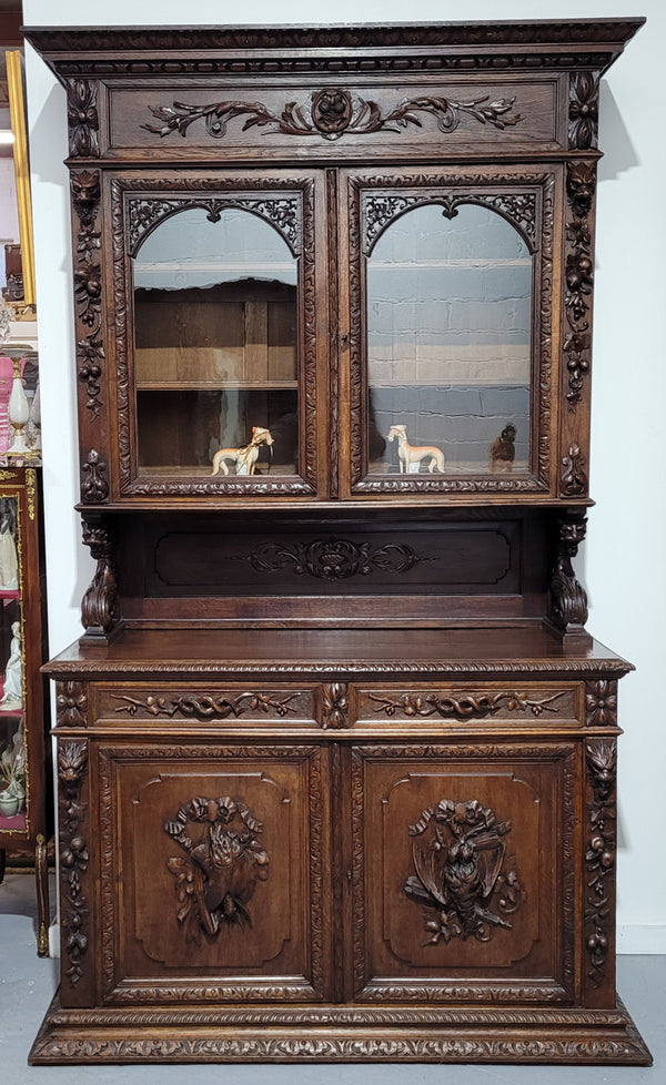 Grand French Oak Gothic style buffet with amazing detailed carvings. This stunning buffet has a display section at the top with two adjustable shelves, two drawers in the middle with elegantly carved handles and storage below with one fixed shelf. It is in good original detailed condition.