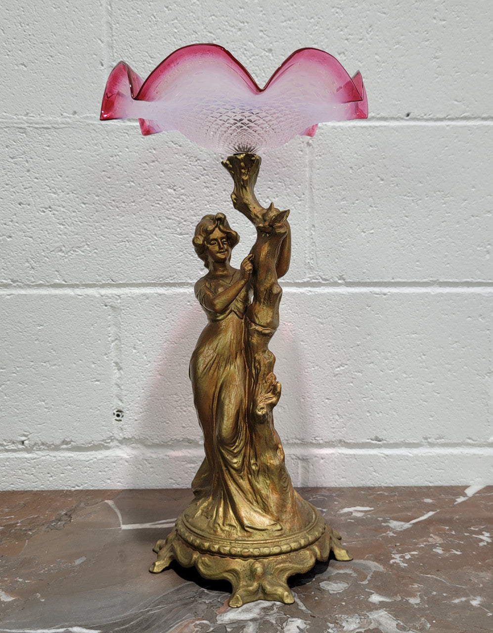 Late Victorian spelter table Centrepiece/comport featuring a woman holding an opalescent and ruby glass bowl. In good original condition with no damage to the ruby bowl.
