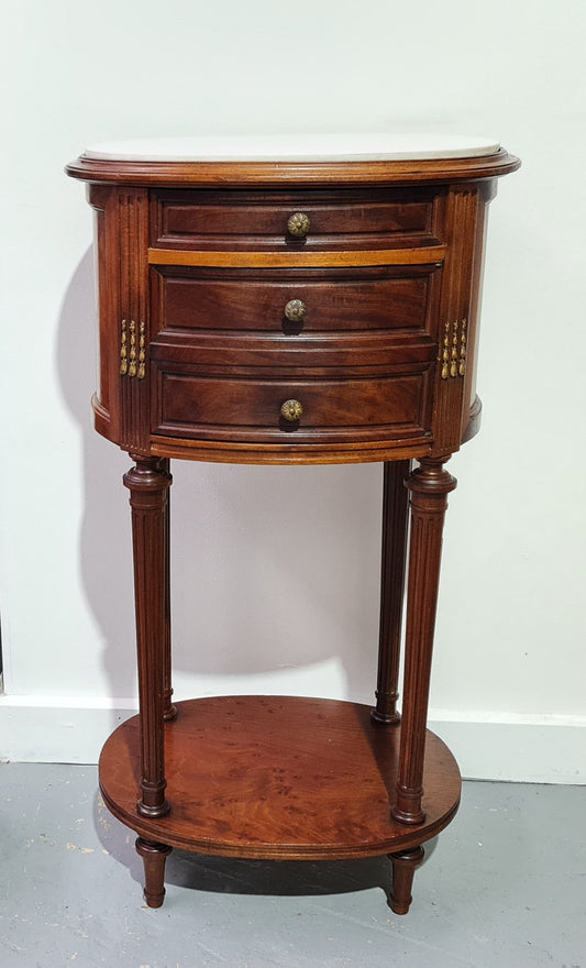 Round Louis XVI style Mahogany marble top side table. It has one drawer and a cupboard for storage. It is in good original detailed condition.