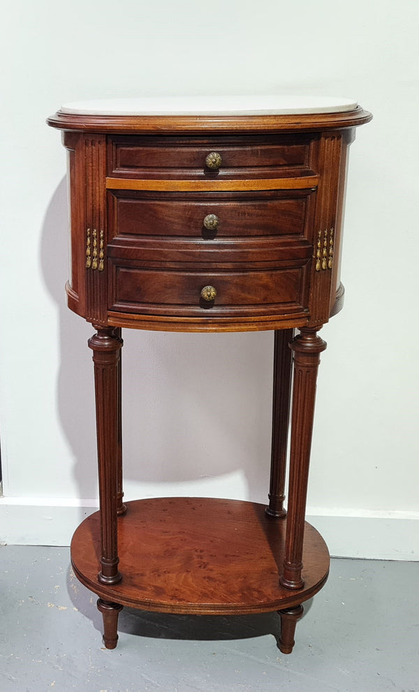 Round Louis XVI style Mahogany marble top side table. It has one drawer and a cupboard for storage. It is in good original detailed condition.