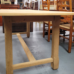 French raw Oak stretcher based refectory table. Features raw wood that could be used as is for a distressed look, or finished and waxed for a more refined look. Sourced from France and in good original condition.