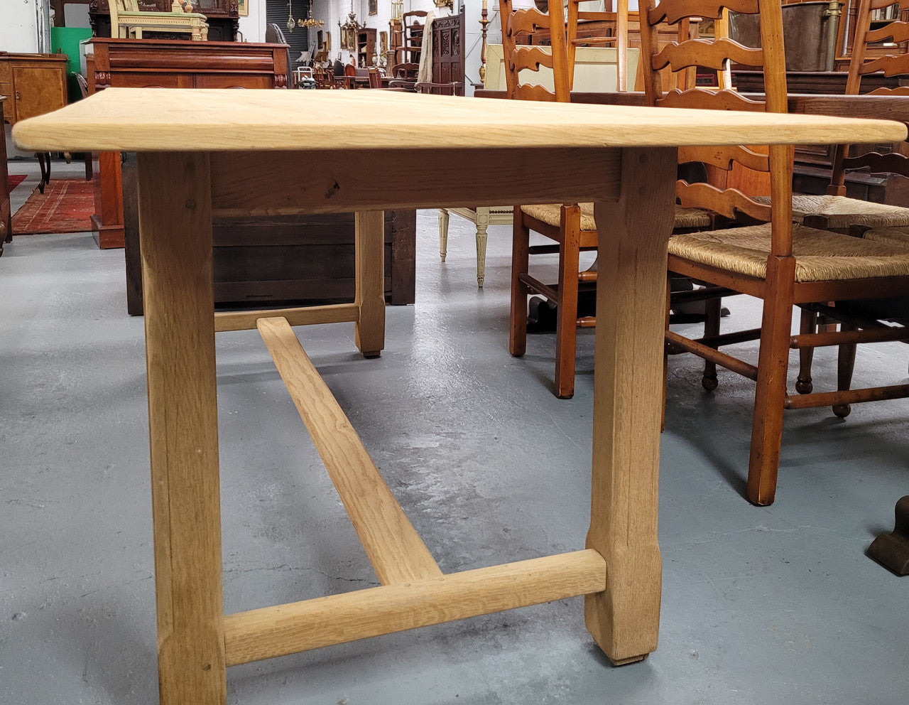 French raw Oak stretcher based refectory table. Features raw wood that could be used as is for a distressed look, or finished and waxed for a more refined look. Sourced from France and in good original condition.