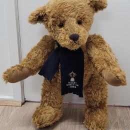 World Cup Rugby Bear. William by RUSS a special release for 2003. Limited to 5000 pieces worldwide. 50.8 cm fully jointed golden-brown bear with suedeen paw pads and blue scarf with Rugby World Cup Logo embroidery.

*Please note chair in photo is not included.