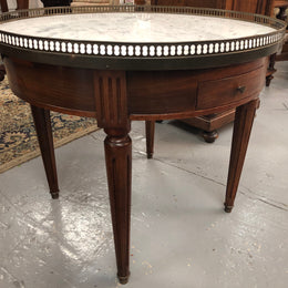Large French Bouillotte table with a marble top and brass fitted gallery. It has two concealed leather - topped slides and two drawers and in good original condition.