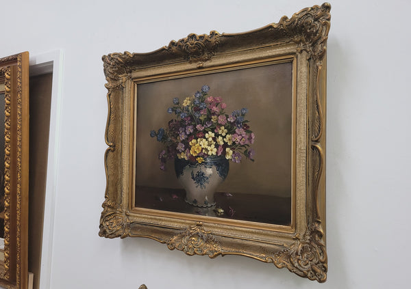Attractive signed oil on canvas depicting flowers in a blue and white Jardinière in a stunning gilt frame. In good original detailed condition.