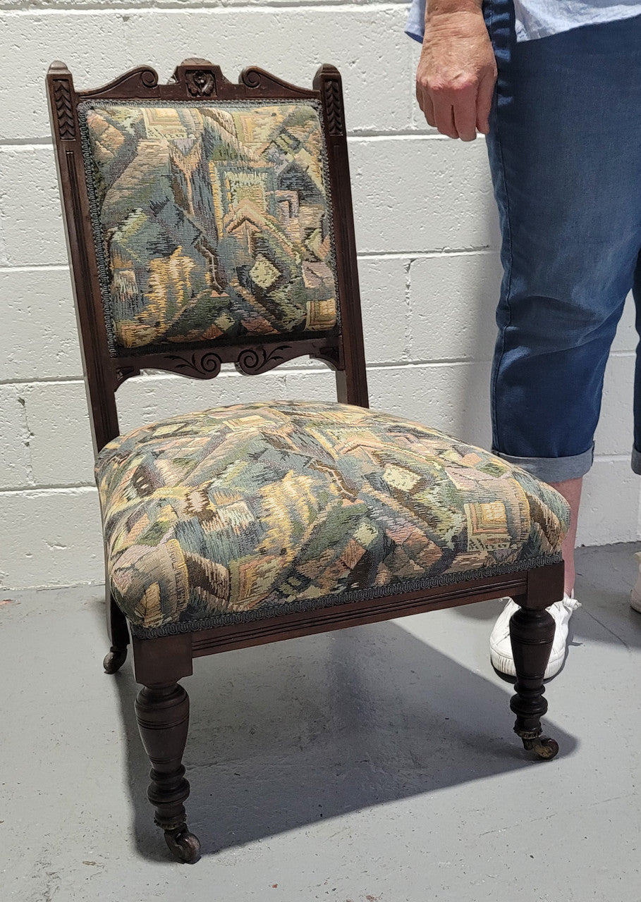 Single upholstered Edwardian nursing chair. Fabric is in good original used condition and chair has four caster wheels and is in good original condition.