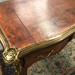 An impressive French Walnut petite Bureau Plat with superb ormolu mounts, original tooled leather top with loads of character and drawers for storage. It is in very good original detailed condition.