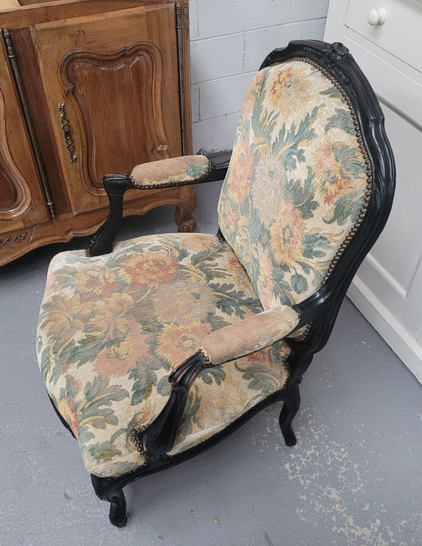 Antique 19th century Louis XV style ebonized upholstered armchairs. The fabric is in good used condition showing signs of use. They can be used as is or reupholstered for a new look.