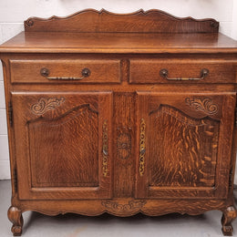 French Louis XV style Oak two door, two drawer sideboard. It is of pleasing narrow proportions and has one interior shelf. It has been sourced from France and it is in good original detailed condition.