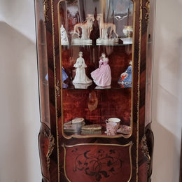 French Louis XV style marquetry inlaid vitrine with ormolu mounts and curved glass. The inside in lined with a red velvet upholstery and has two glass shelves. It has been sourced from France and is in good original detailed condition.