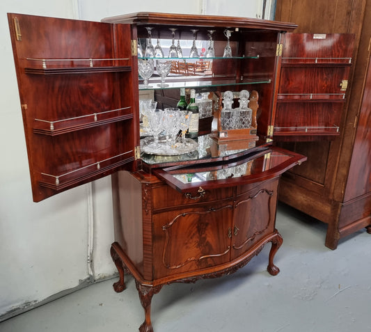 1950’s Chippendale Style Flame Mahogany Four door Bar. The top section has glass shelves and a mirrored pull out tray for storing glasses, decanters & serving etc. It also has a silver presentation plaque to the Mayor of Hawthorn 1958. The bottom section is for storage bottles etc. A stunning and practical piece.