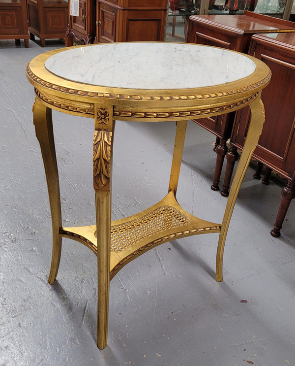 Impressive French oval Louis XVI style gilt and white marble topped two tier lamp/side table. It has been sourced from France and is in good original detailed condition.