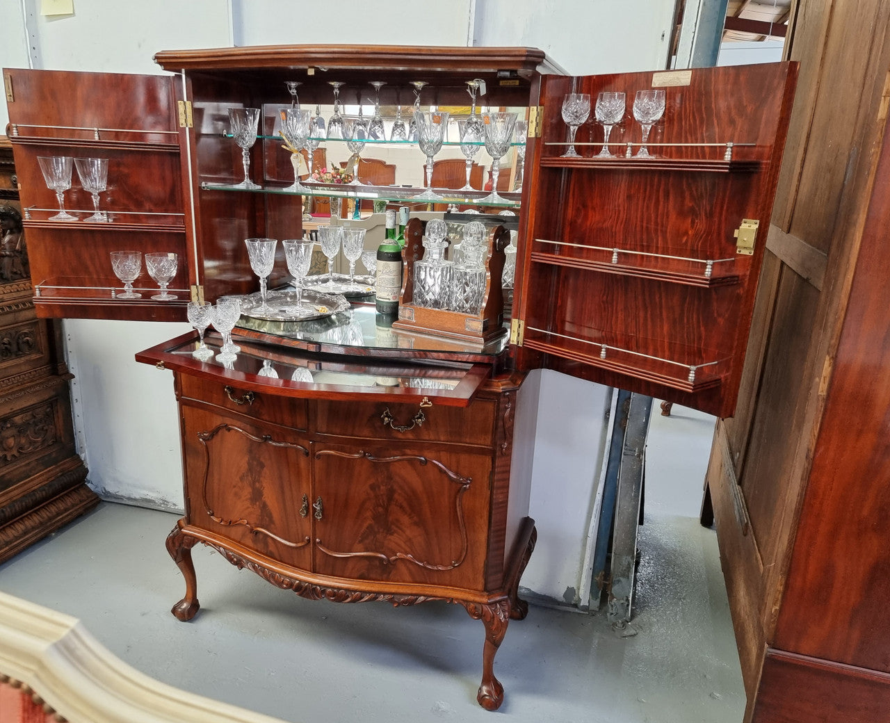 1950’s Chippendale Style Flame Mahogany Four door Bar. The top section has glass shelves and a mirrored pull out tray for storing glasses, decanters & serving etc. It also has a silver presentation plaque to the Mayor of Hawthorn 1958. The bottom section is for storage bottles etc. A stunning and practical piece.
