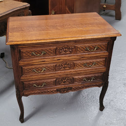 Rustic Louis XV style Oak petite three drawer chest featuring attractive carvings. It has been sourced locally and it is in good original detailed condition.