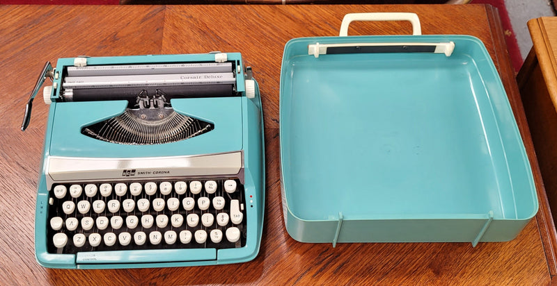 1960's Smith Corona Corsair deluxe portable typewriter. It is in working condition with a used ribbon, and comes with everything pictured. It has been sourced locally.