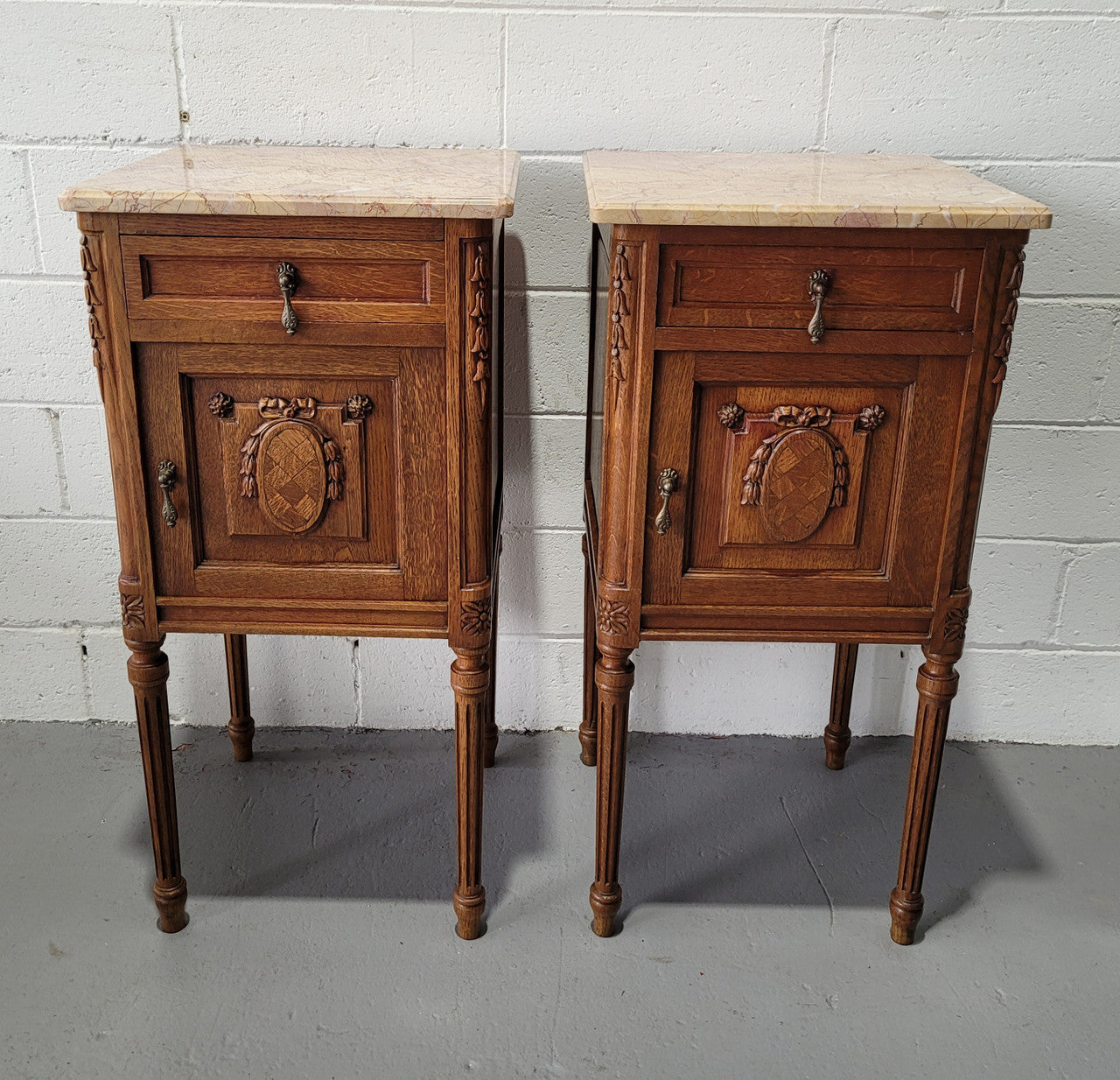 Pair of Louis XV French Oak and marble top bedside cabinets. They have beautiful detailed carving and stunning color marble top. They are in very good original detailed condition.