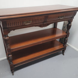 Fabulous quality Edwardian Walnut dumb waiter. It has two drawers and two shelves and is on casters. In good original detailed condition.