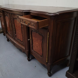 Fabulous Louis XV style French Walnut and Burr Walnut four door sideboard. Each door panel has beautiful Burr Walnut panels and open up to an adjustable shelf. Beautiful handles and two drawers for added storage. In good original detailed condition.