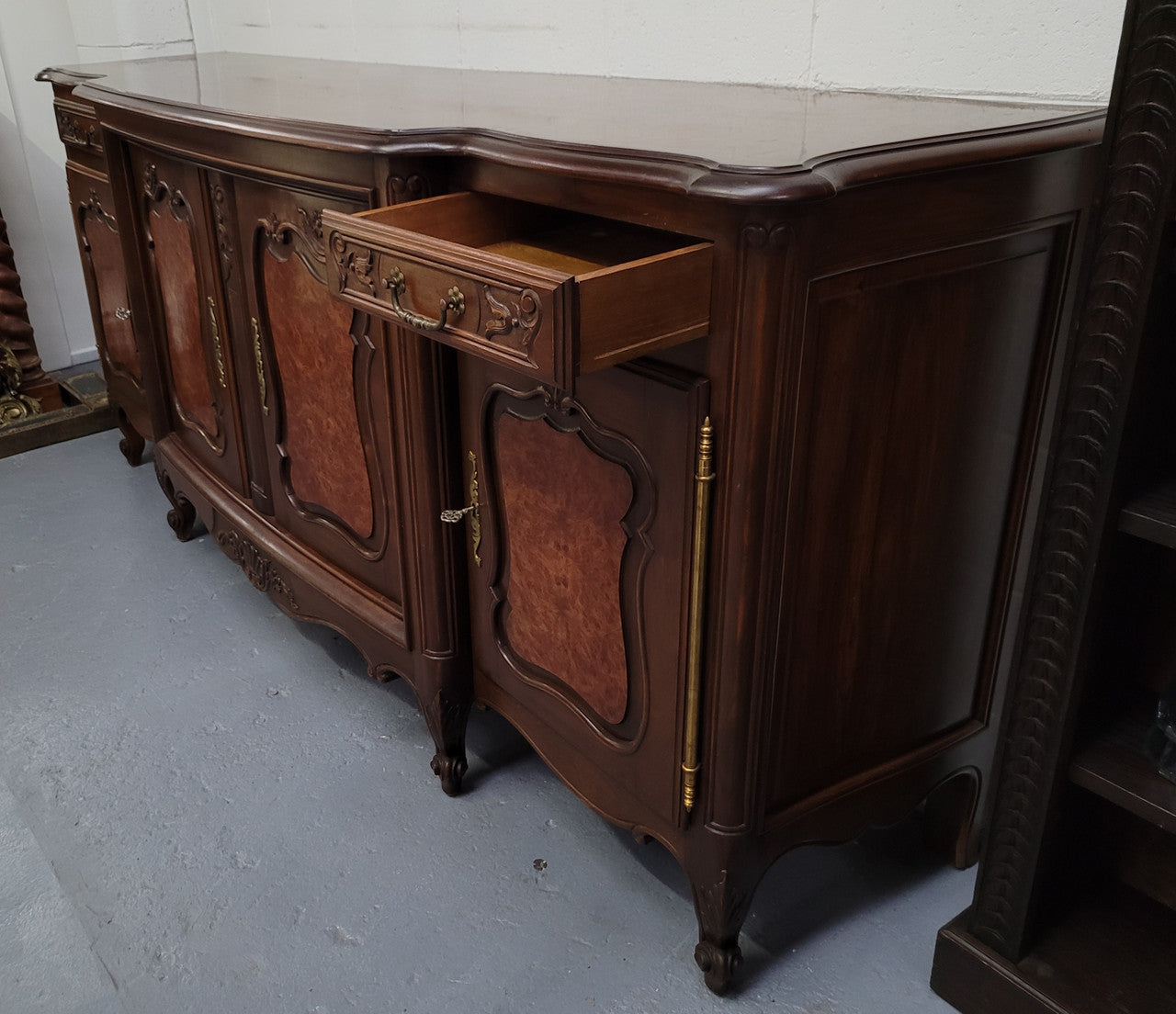 Fabulous Louis XV style French Walnut and Burr Walnut four door sideboard. Each door panel has beautiful Burr Walnut panels and open up to an adjustable shelf. Beautiful handles and two drawers for added storage. In good original detailed condition.