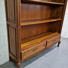 Lovely French Oak Louis XV style open shelf bookcase with two drawers for storage and three shelves in good original detailed condition.
