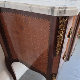 Lovely French Louis XV/XVI style Transitional marquetry inlaid commode. There are two drawers and beautiful ormolu mounts with a nice marble top in good original detailed condition.