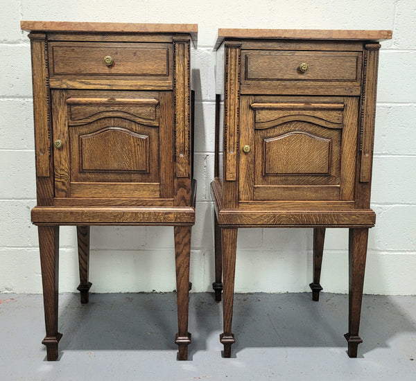 Beautiful pair of French oak bedside cabinets with marble tops. They have a drawer and cupboard for storage and are in good original detailed condition.