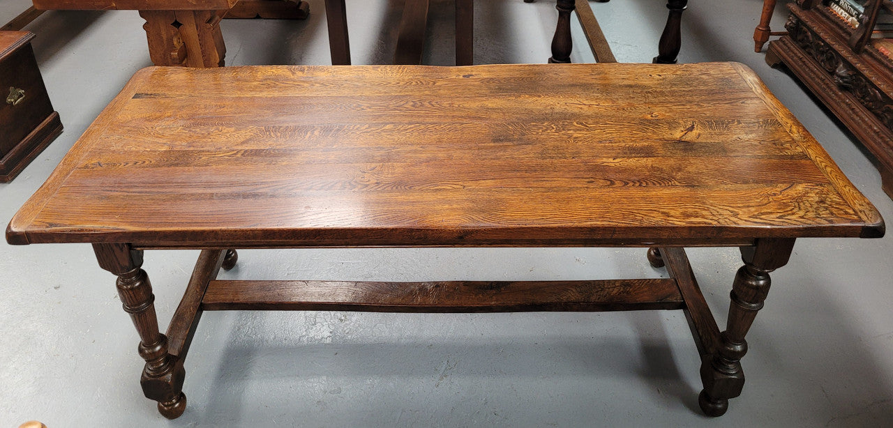 Rustic French Oak stretcher based farmhouse dining table that comfortably seats 6-8 people. It has been sourced from France and is in good original condition.