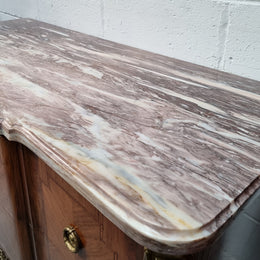 A stunning French transitional Louis XV and Louis XVI style commode. It has beautiful walnut inlay and a fabulous marble top. Comes with two drawers and fitted with gilt brass mounts. it is In very good original condition.
