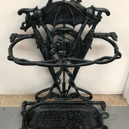 A black cast iron umbrella stand displaying a horse in the middle with four dogs on the side. In good original condition.