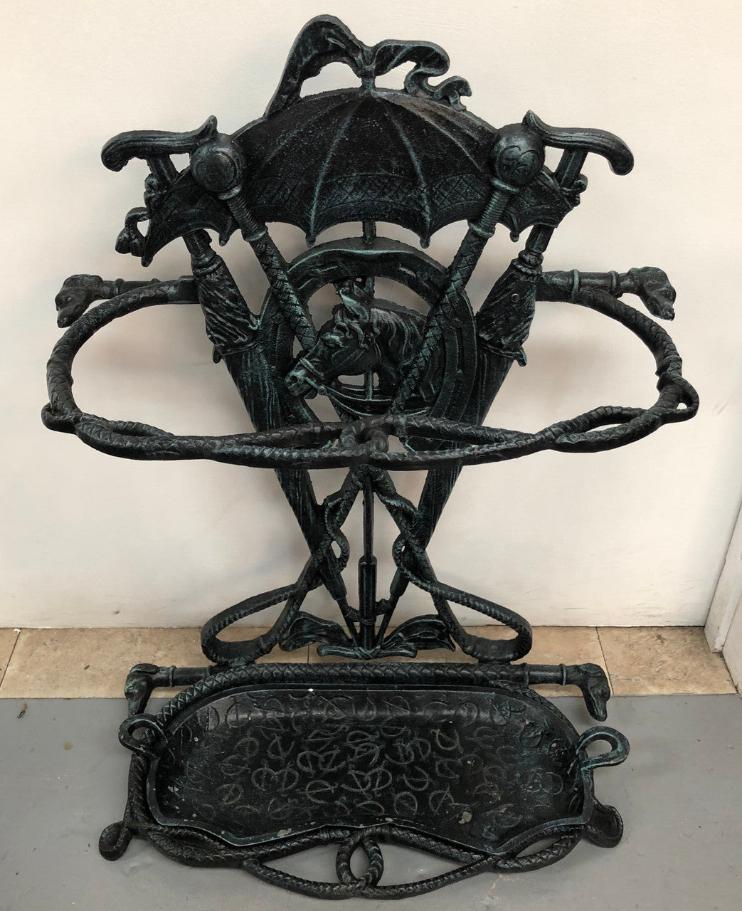 A black cast iron umbrella stand displaying a horse in the middle with four dogs on the side. In good original condition.